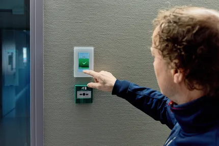 Medewerker van Unica bedient een touchpanel aan een technische installatie en checkt de status