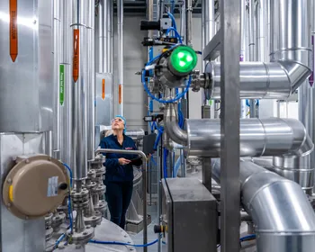 Een medewerker controleert leidingen in een industriële procesomgeving, met nadruk op RVS-installaties en meet- en regeltechniek.