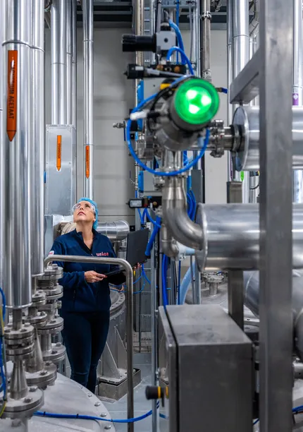 Een medewerker controleert leidingen in een industriële procesomgeving, met nadruk op RVS-installaties en meet- en regeltechniek.