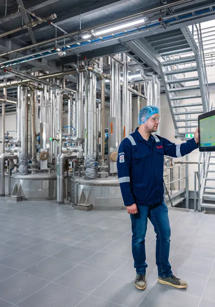 Een Unica-specialist bedient zelfstandig een SCADA-interface in een ruimte met uitgebreide procesleidingen.
