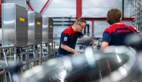 Unica-technicus inspecteert roestvrijstalen tank in een industriële procesruimte