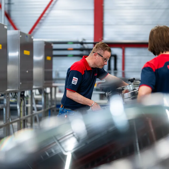 Unica-technicus inspecteert roestvrijstalen tank in een industriële procesruimte