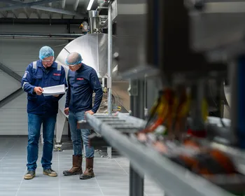 Twee Unica-engineers controleren technische documenten bij een industriële installatie