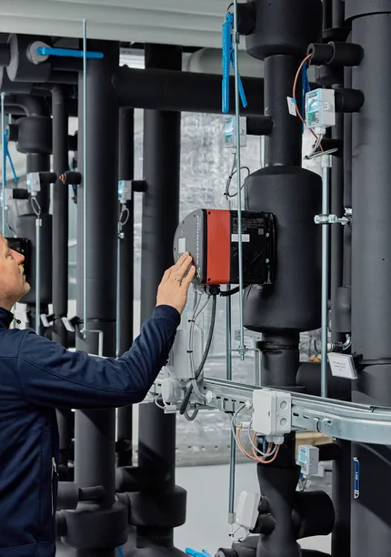Medewerker van Unica bekijkt de regeltechnische installatie in de technische ruimte