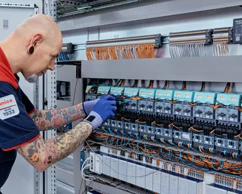 Medewerker van Unica is met gereedschap aan het werk in een regelkast