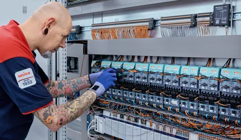 Medewerker van Unica is met gereedschap aan het werk in een regelkast