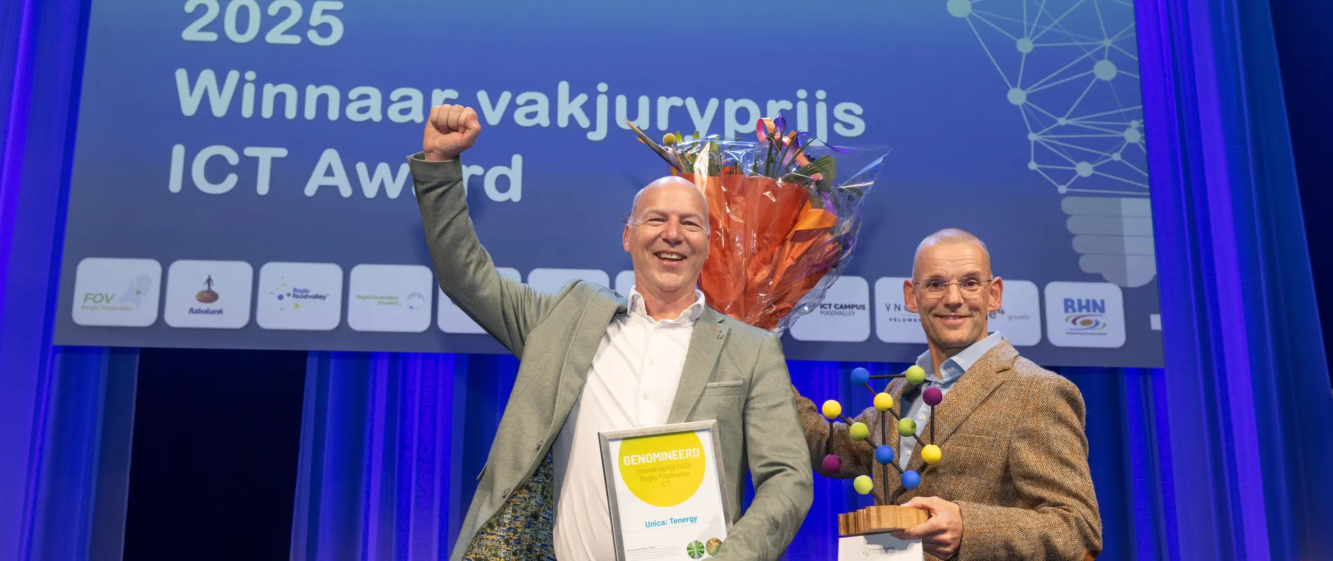 Edwin Koers en Dik Geelen van Unica nemen juigend de innovatieprijs in ontvangst tijdens Regio Foodvalley 2025