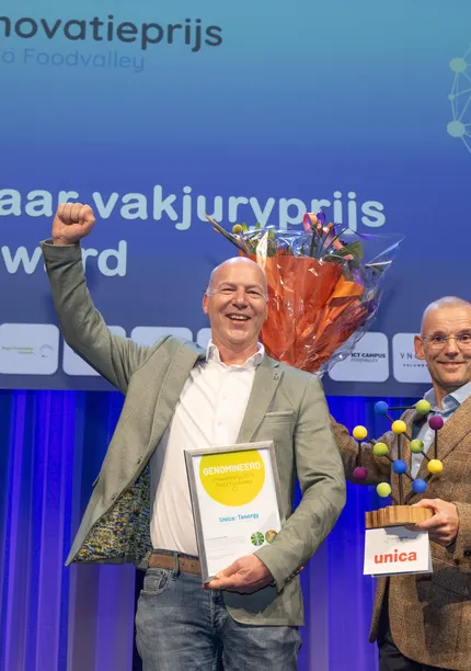 Edwin Koers en Dik Geelen van Unica nemen juigend de innovatieprijs in ontvangst tijdens Regio Foodvalley 2025