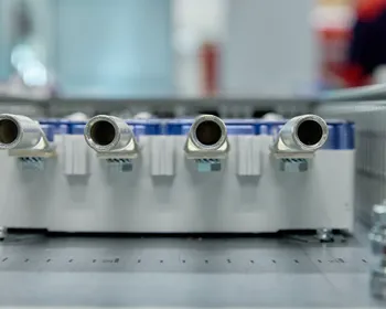Close-up van vier metalen aansluitnippels op een module in een regel- of verdeelkast, onderdeel van een gebouwbeheersysteem of HVAC-installatie.