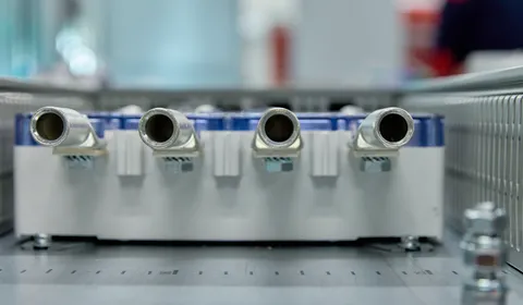 Close-up van vier metalen aansluitnippels op een module in een regel- of verdeelkast, onderdeel van een gebouwbeheersysteem of HVAC-installatie.
