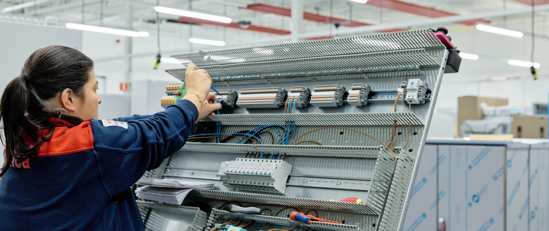 Medewerker van Unica werkt aan regelkast met schroevendraaier