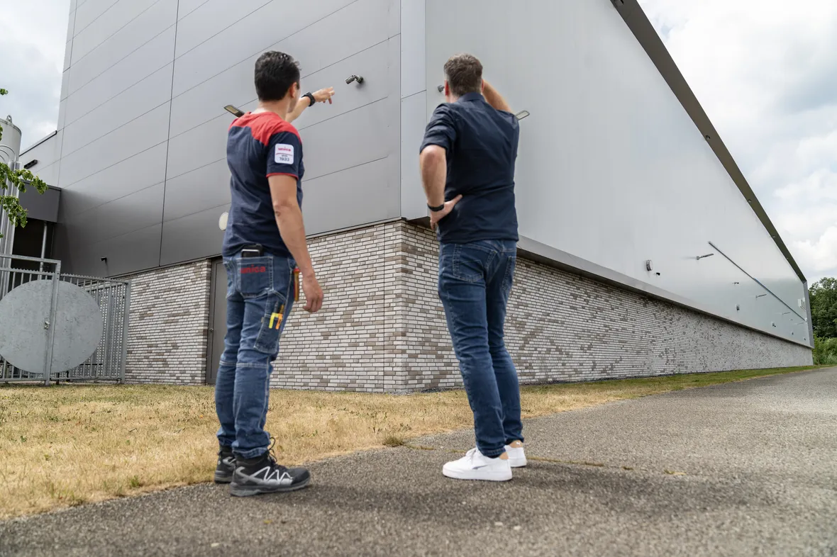 Twee mannen kijken naar een camera op een pand