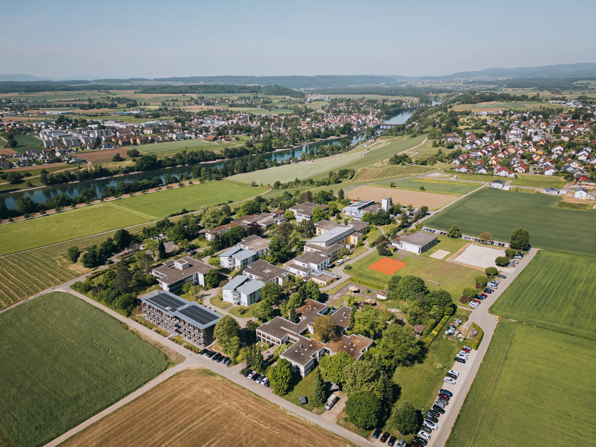Luftbildaufnahme des Klinikgeländes Hegau-Jugendwerk inklusive Rhein und Schweizer Seite mit Diessenhofen.