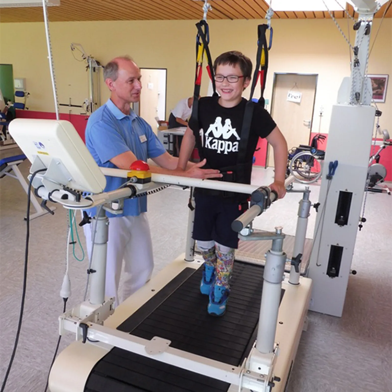 Junger Rehabilitand beim therapeutischen Laufbandtraining mit physiotherapeutischer Begleitung im Hegau-Jugendwerk Gailingen.