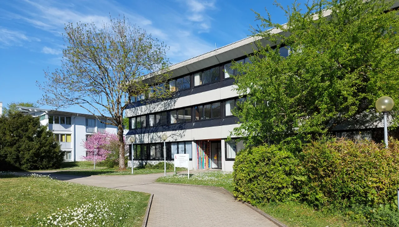 Klinikschule des Hegau-Jugendwerks (SBBZ) umgeben von schönen grünen Bäumen.