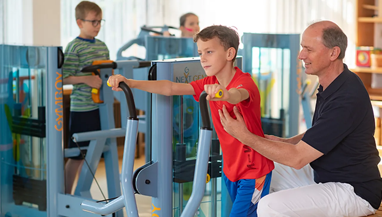 Medizinische Trainingstherapie im Hegau-Jugendwerk mit Kindern an speziell angepassten Geräten, betreut durch einen Physiotherapeuten.
