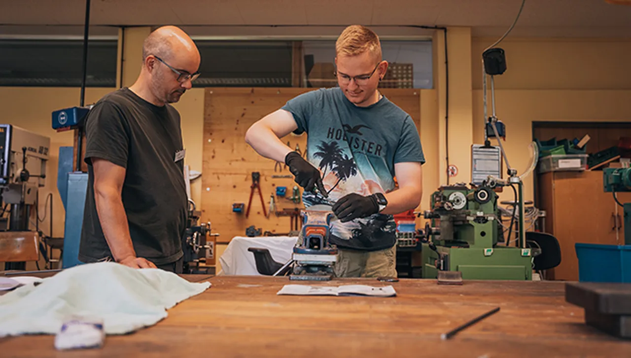 Therapeut mit jungem Rehabilitanden in der Metallwerkstatt des Hegau-Jugendwerks während der berufsvorbereitenden Bildungsmaßnahme BvB 3 Metalltechnik.