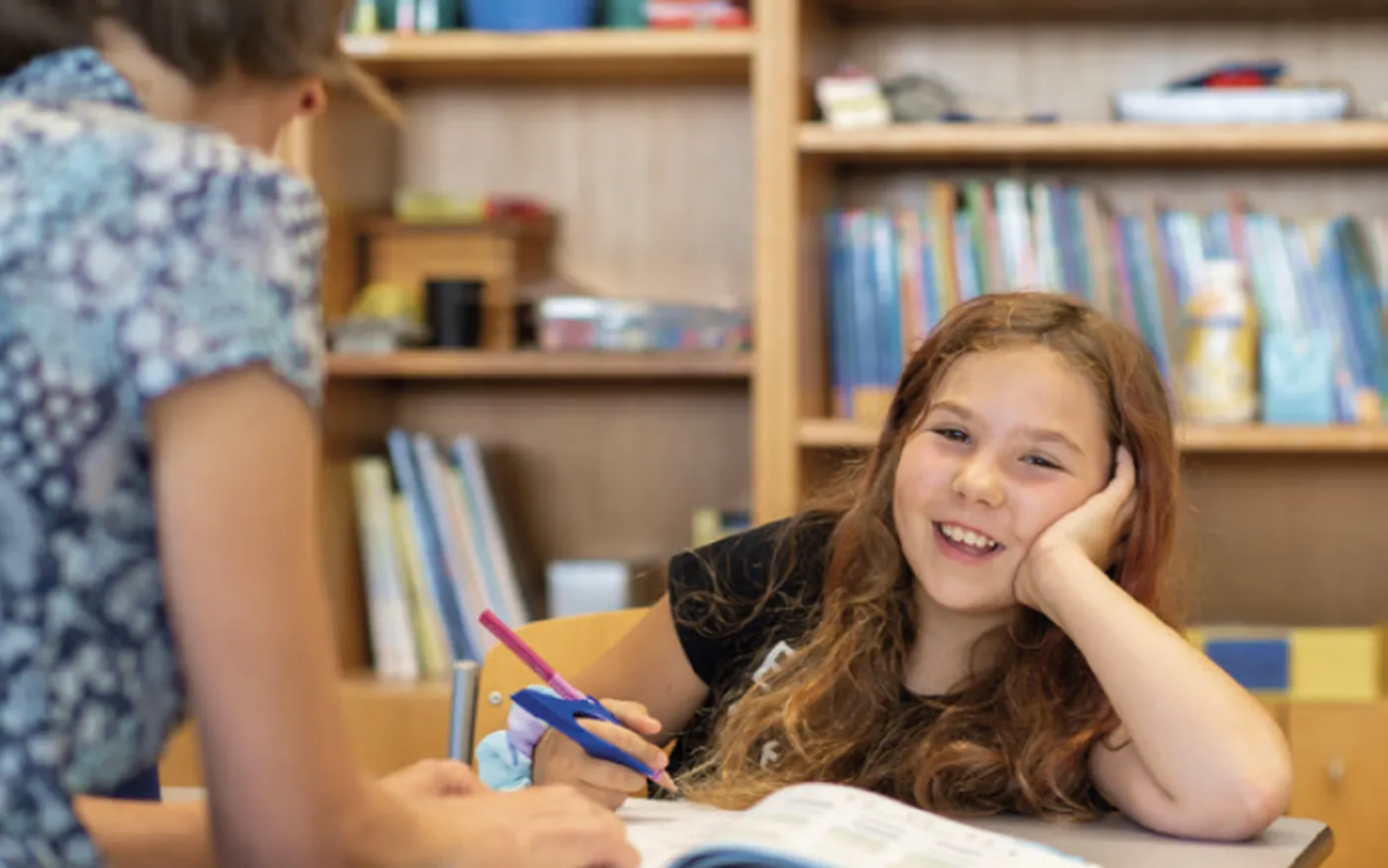 Kind lächelt in Kamera während sie in der Schule lernt