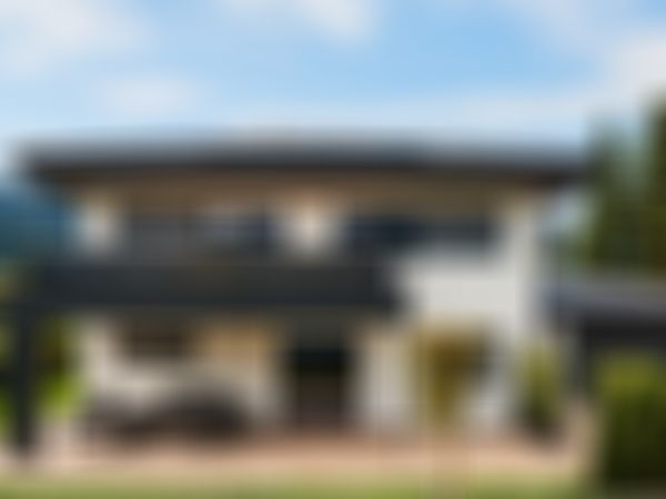 Modern two-story house with a spacious patio, solar panels on the roof, and scenic mountain views in the background.