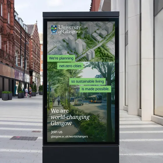 Digital billboard on a city street displays a University of Glasgow ad