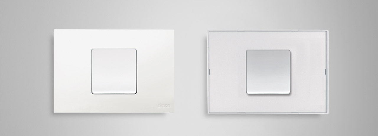 Dos placas Simon 27 Play: acabado blanco y acabado transparente sobre fondo gris.