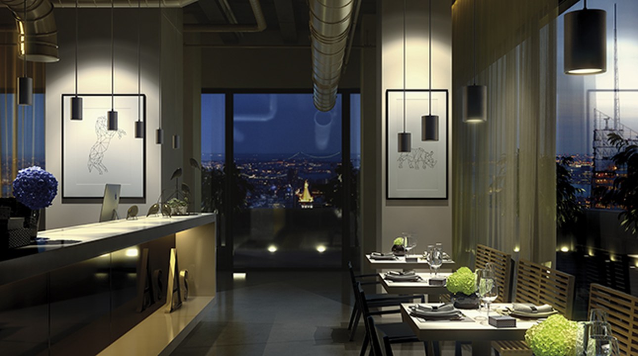 Nighttime restaurant with panoramic views lit by suspended black Simon 640 spotlights