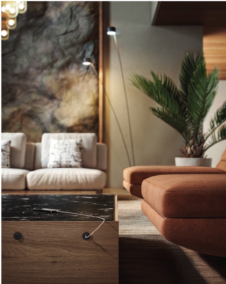 Simon Flash on a marble side table in a warm lobby with sofa, lamp and plant