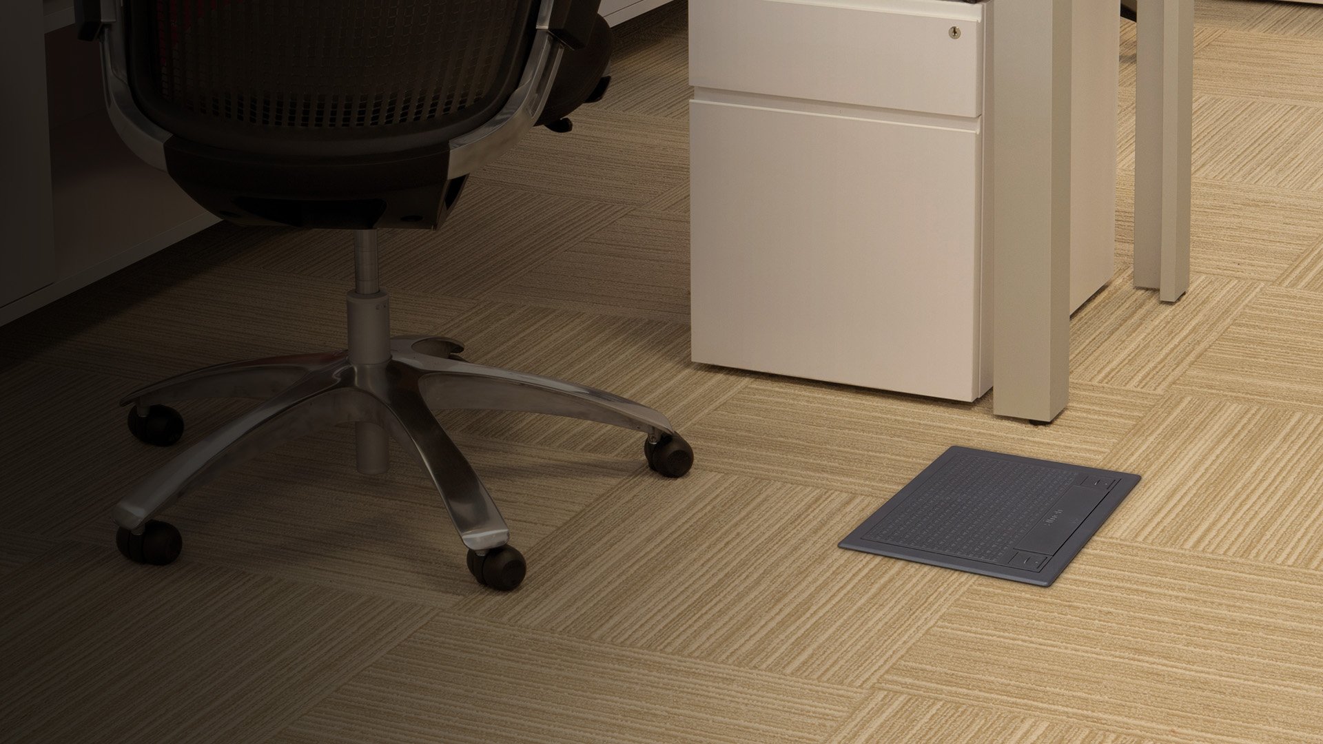Ambiente de oficina con caja Simon S integrada en el pavimento bajo el área de trabajo.