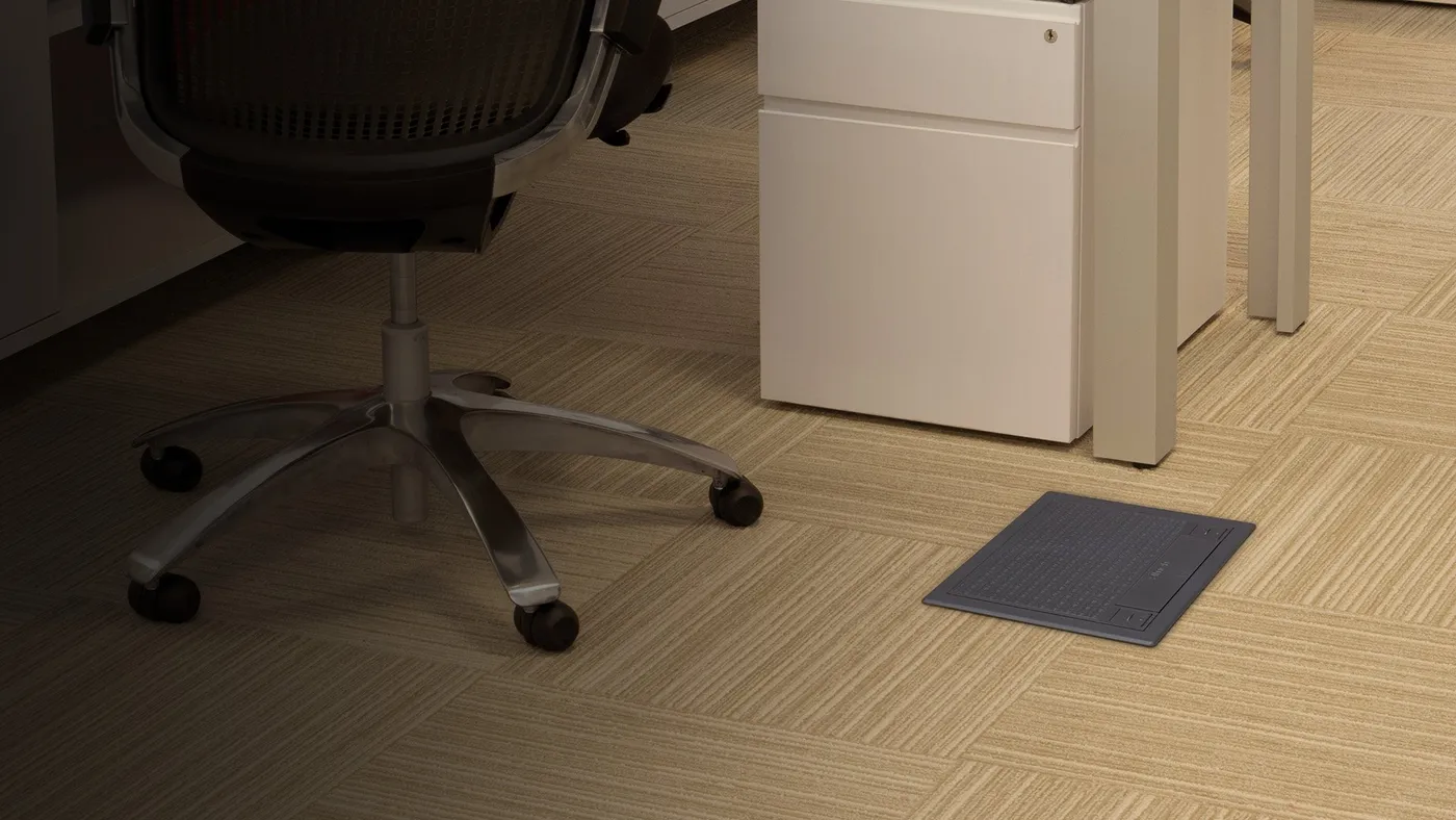 Ambiente de oficina con caja Simon S integrada en el pavimento bajo el área de trabajo.