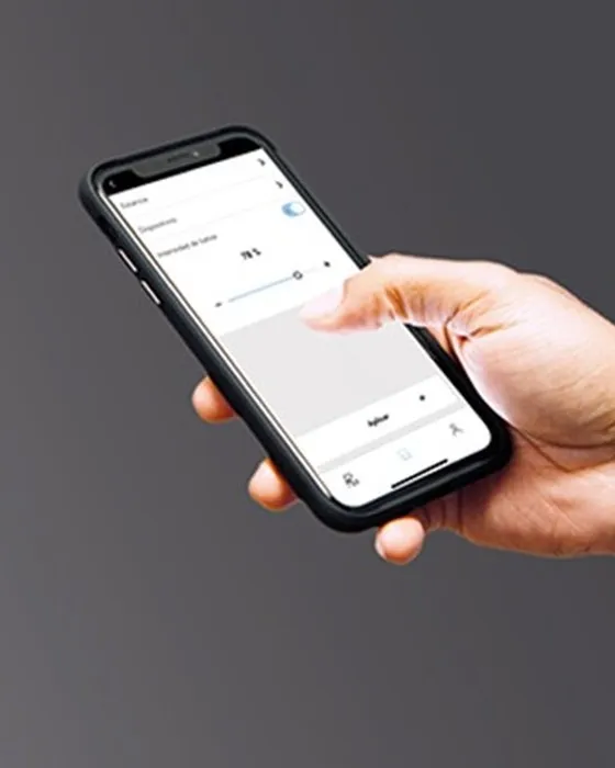Hand holding a phone with the Simon iO app for smart lighting control