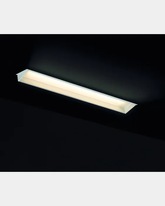 Simon 712 linear downlight switched on with warm light against dark background