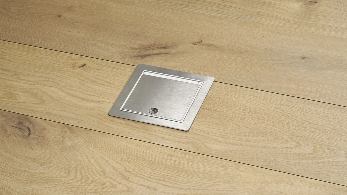 Caixa de chão IP66 com aro exterior instalada em pavimento técnico de parquet