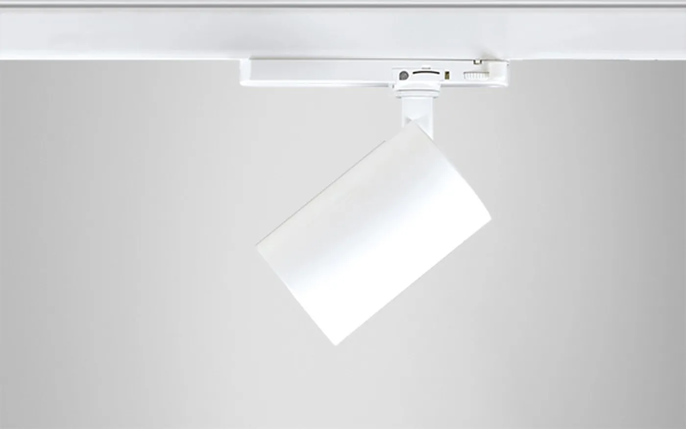 Spot cylindrique Simon 615 blanc vue 3/4 sur rail montrant la rotation et le basculement
