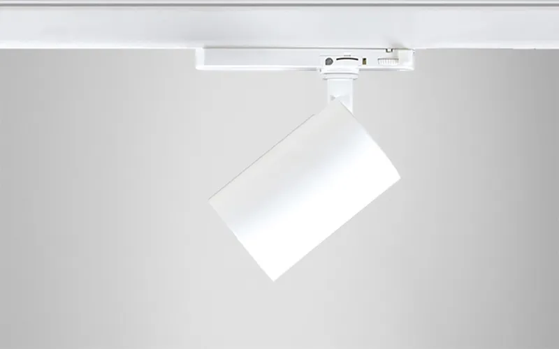 Spot cylindrique Simon 615 blanc vue 3/4 sur rail montrant la rotation et le basculement