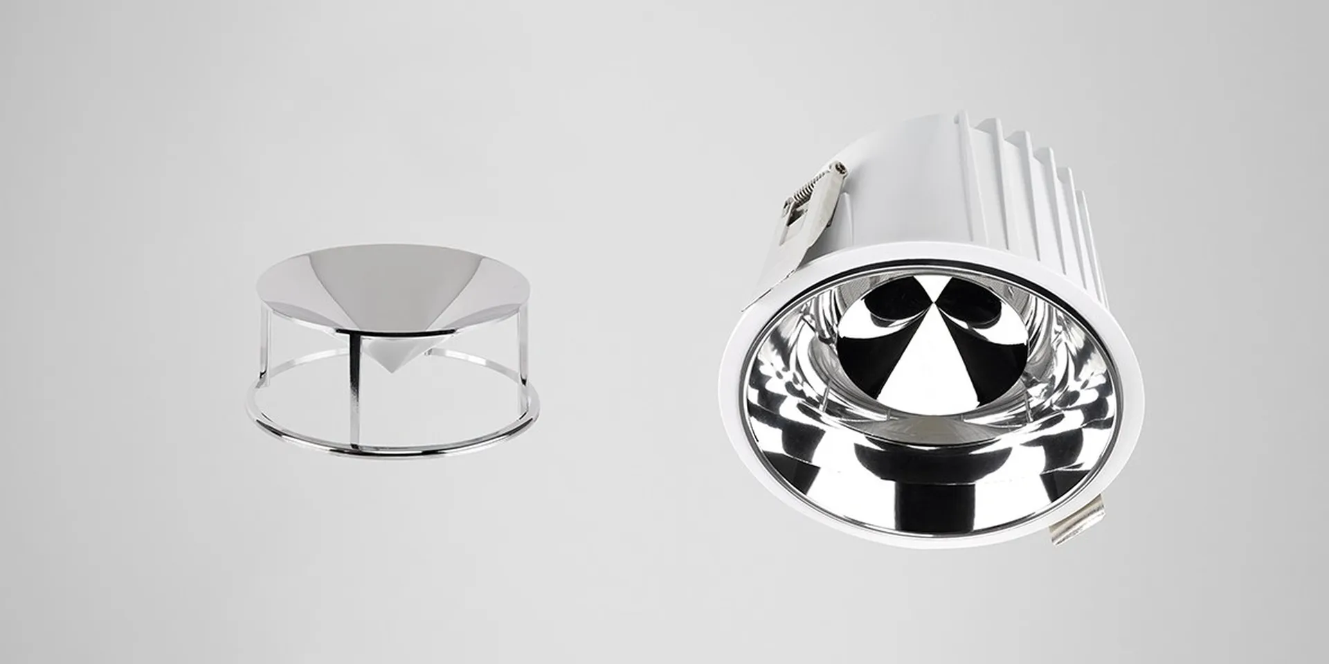 Simon 800 downlight (right) with chrome cone accessory (left) on light grey background