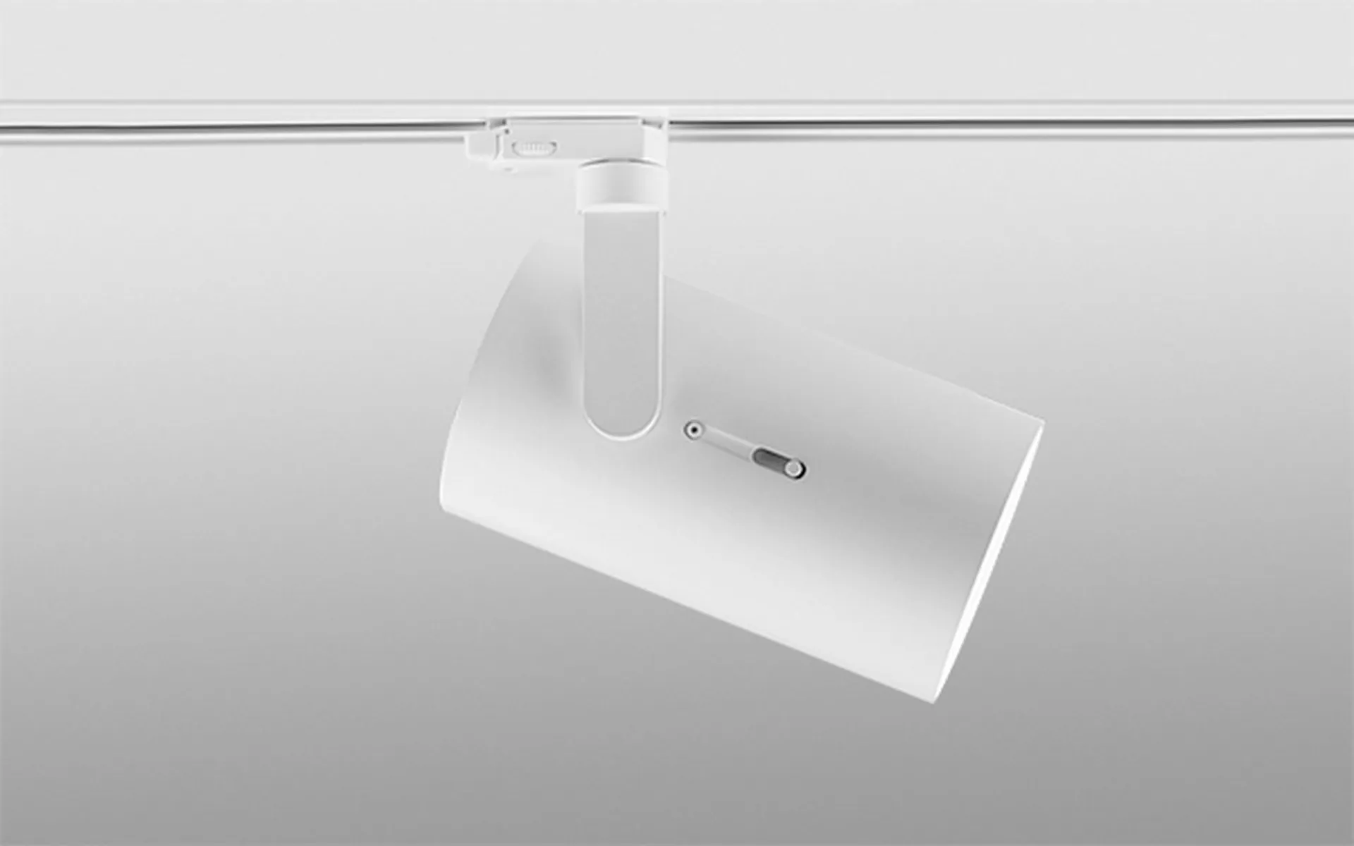 Proyector Simon Point sobre fondo gris claro mostrando el diseño minimalista de la luminaria