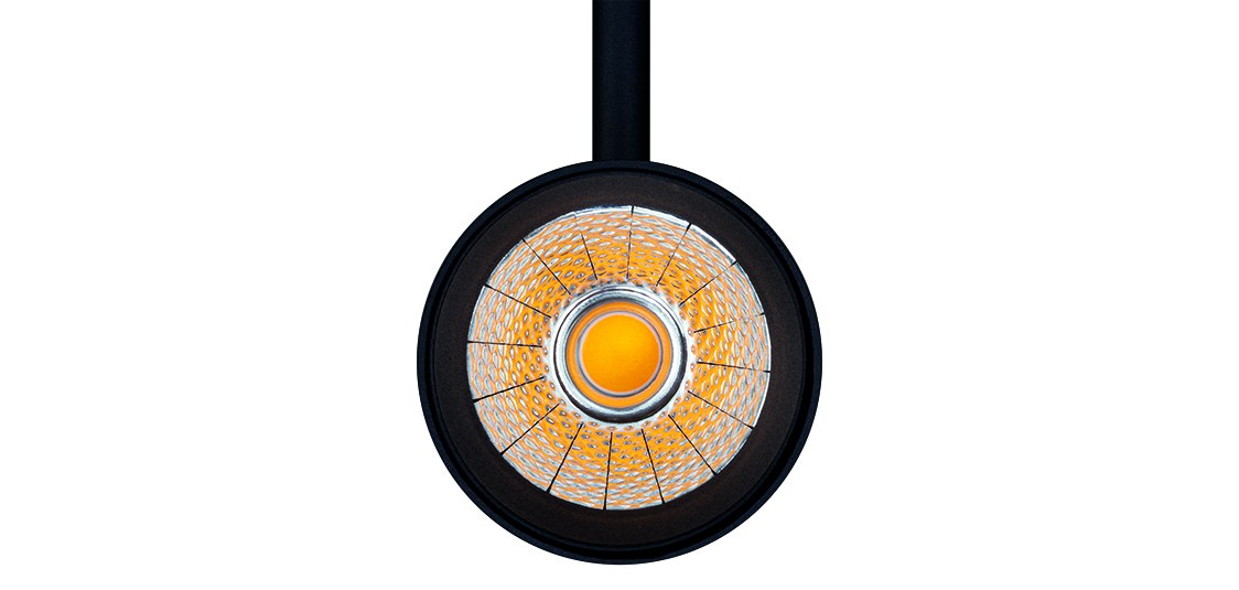Front view of black Simon 629 with COB LED switched on in warm light — optical detail