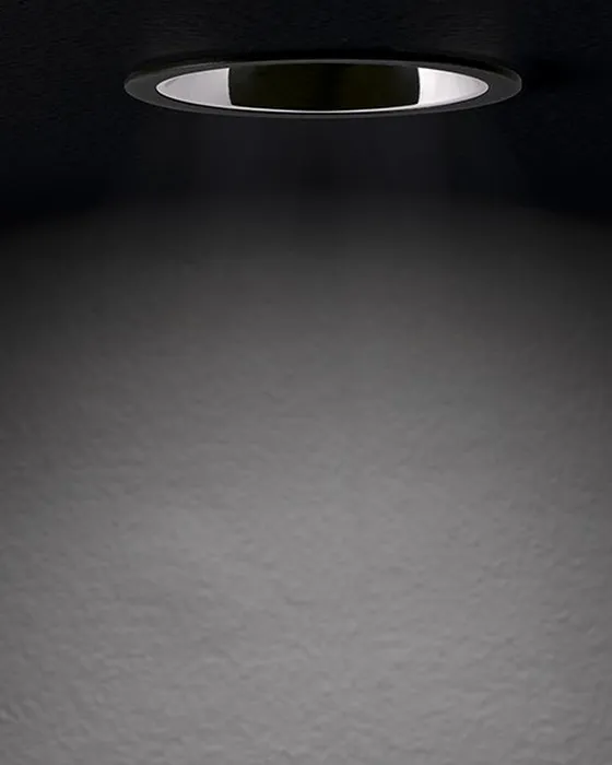Simon 800 downlight illuminating a wall with a uniform beam of light in a dark space — atmospheric scene