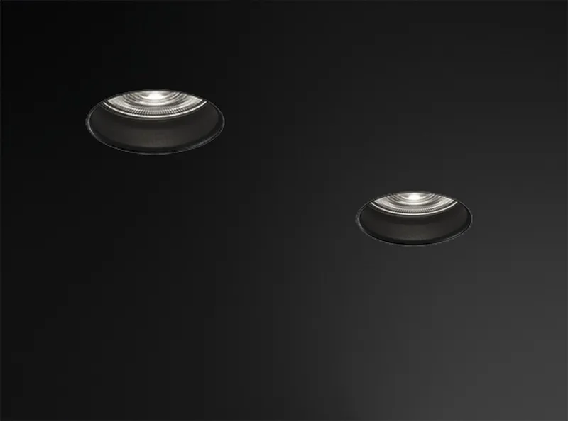 Two Simon Hole cylindrical downlights switched on against dark background