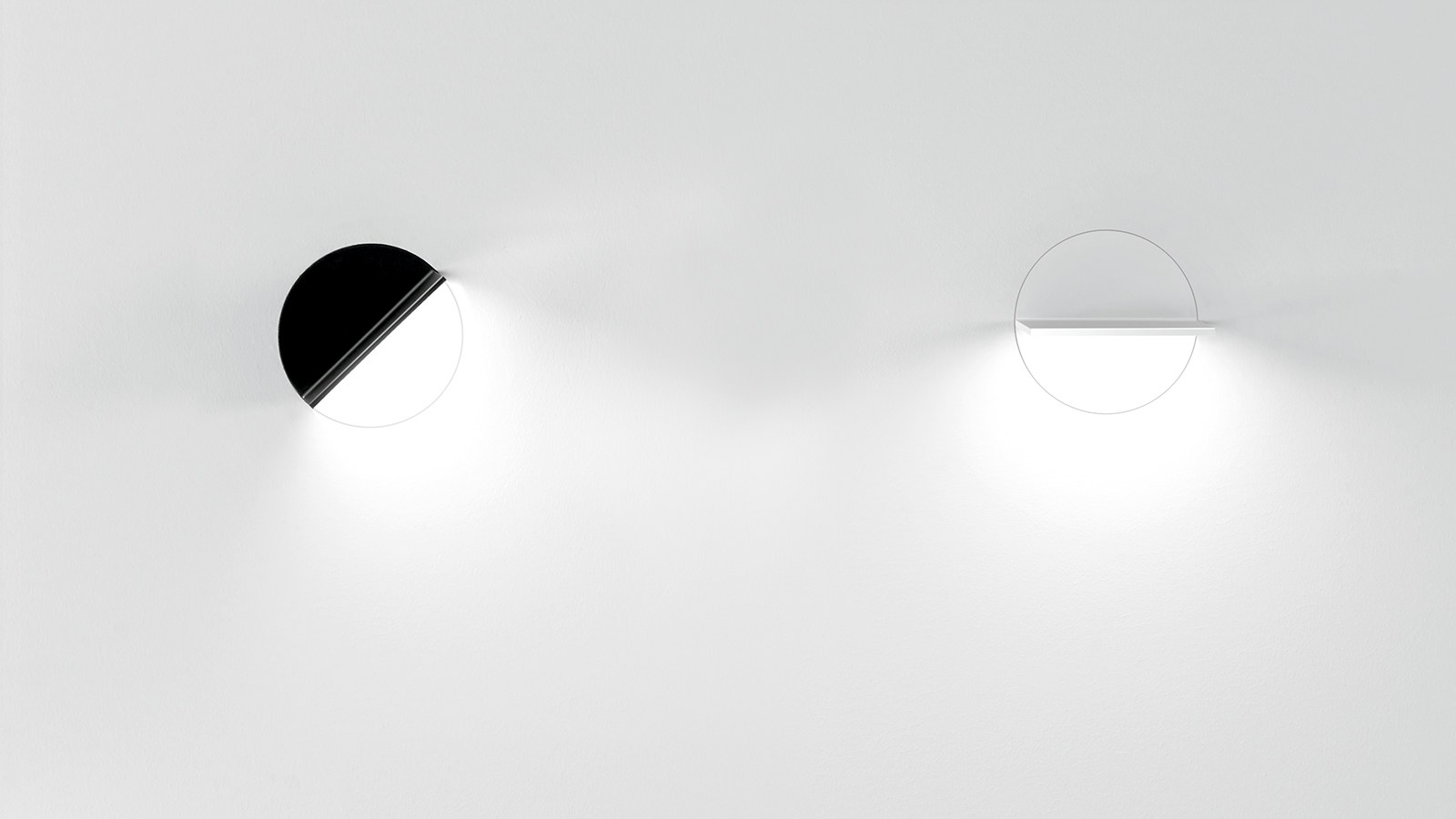 Dos luminarias Simon Loop (acabados blanco y negro) montadas sobre pared mostrando su escalabilidad sobre el plano vertical