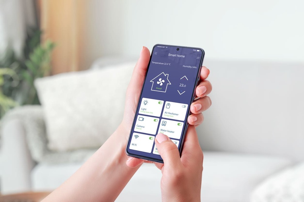 instalaciones domóticas mujer controlando distintos sistemas con su móvil