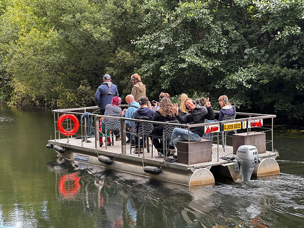 People wearing headphones are on a raft sailiing down the River Tone