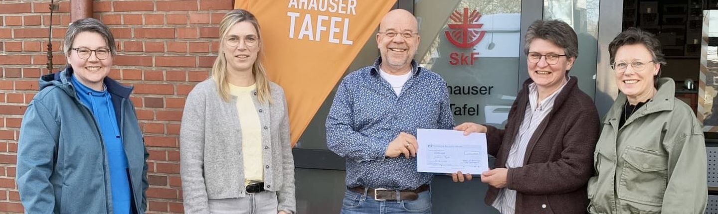 4 Frauen der kfd überreichen Johannes Lügering von der Tafel einen Scheck