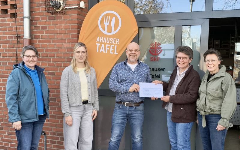 4 Frauen der kfd überreichen Johannes Lügering von der Tafel einen Scheck