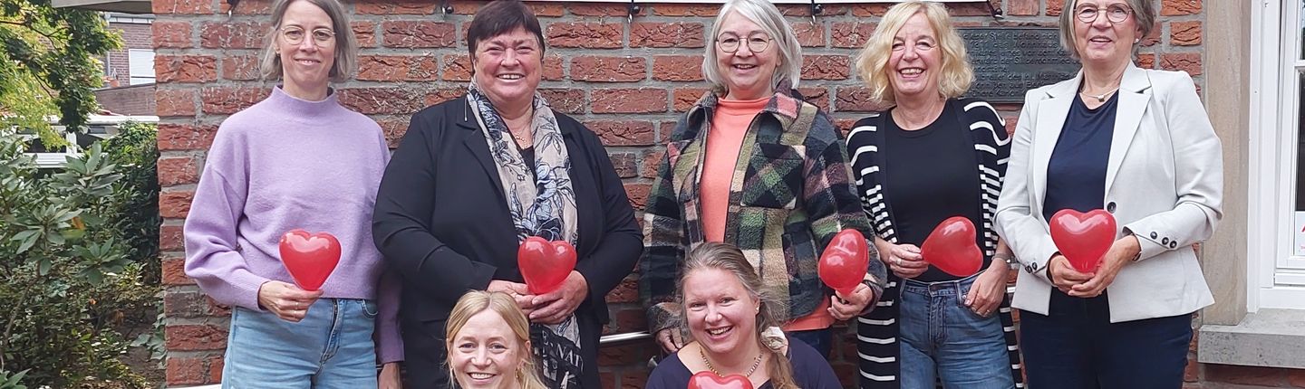 7 Hauptamtliche Mitarbeiterinnen des SkF Ahaus-Vreden mit Herz-Luftnbalons in der Hand