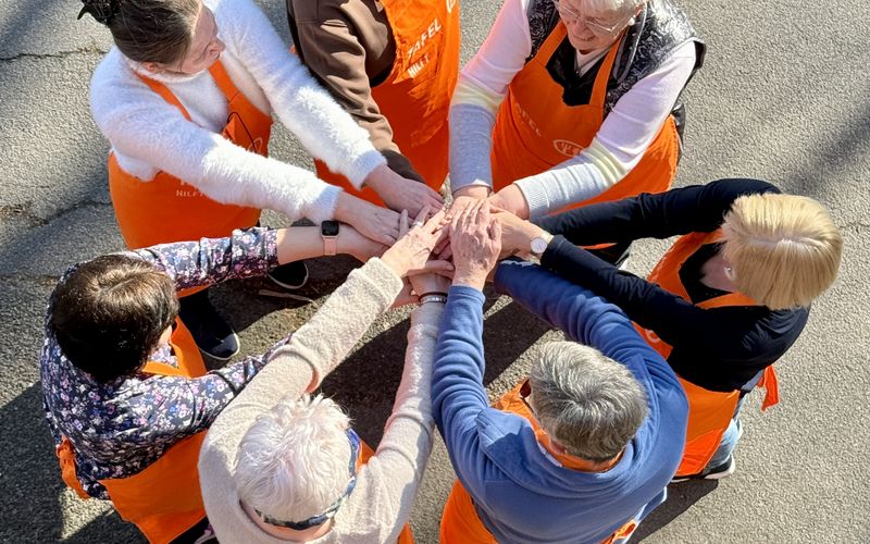 7 Ehrenamtliche der Tafel halten die Hände zusammen