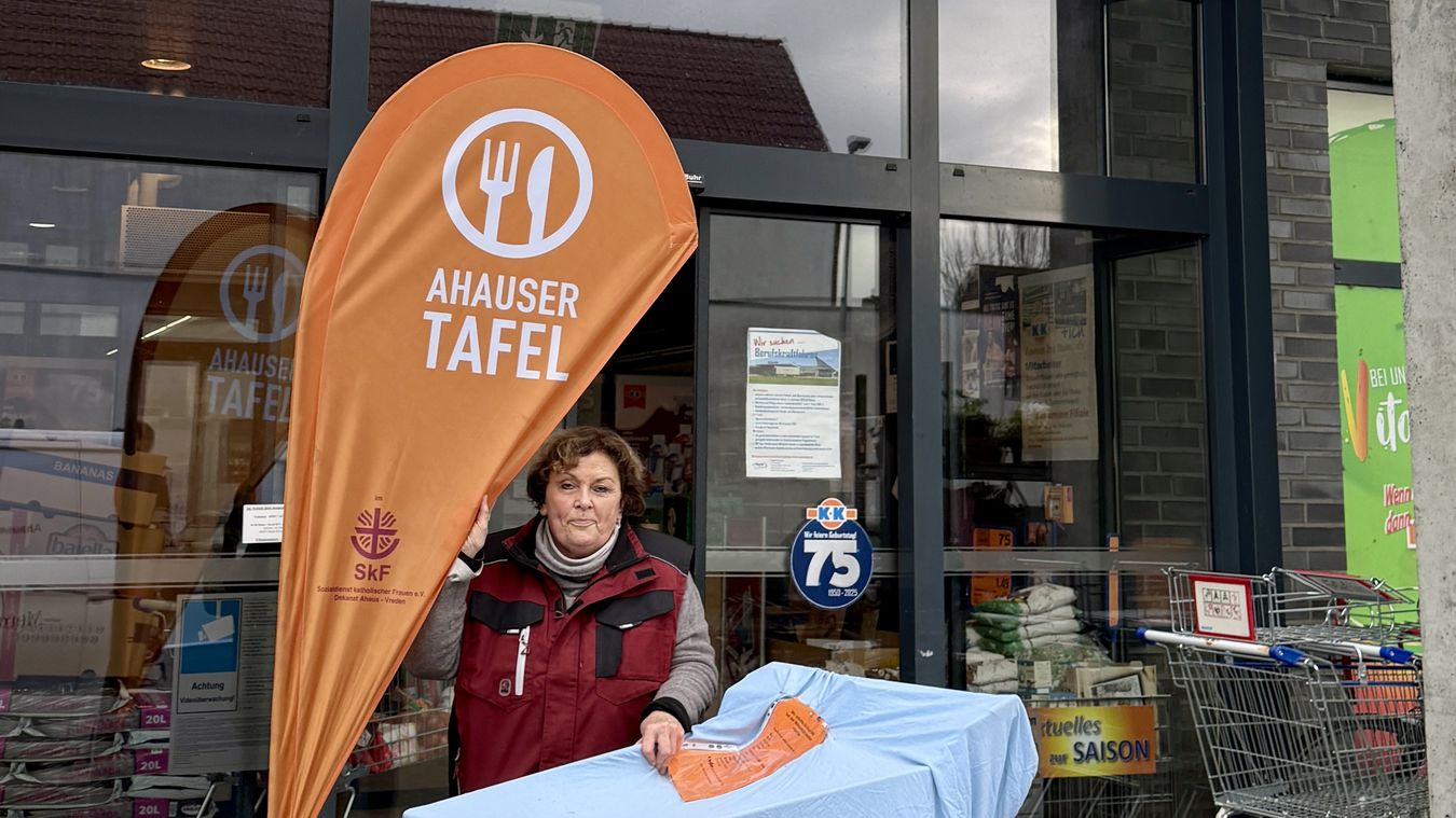 Eine Ehrenamtliche steht vor K+K und sammelt Lebensmittel