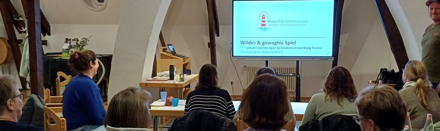 mehrere Teilnehmer schauen auf einen Monitor