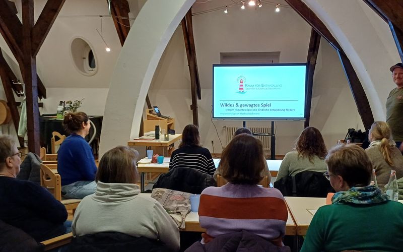 mehrere Teilnehmer schauen auf einen Monitor