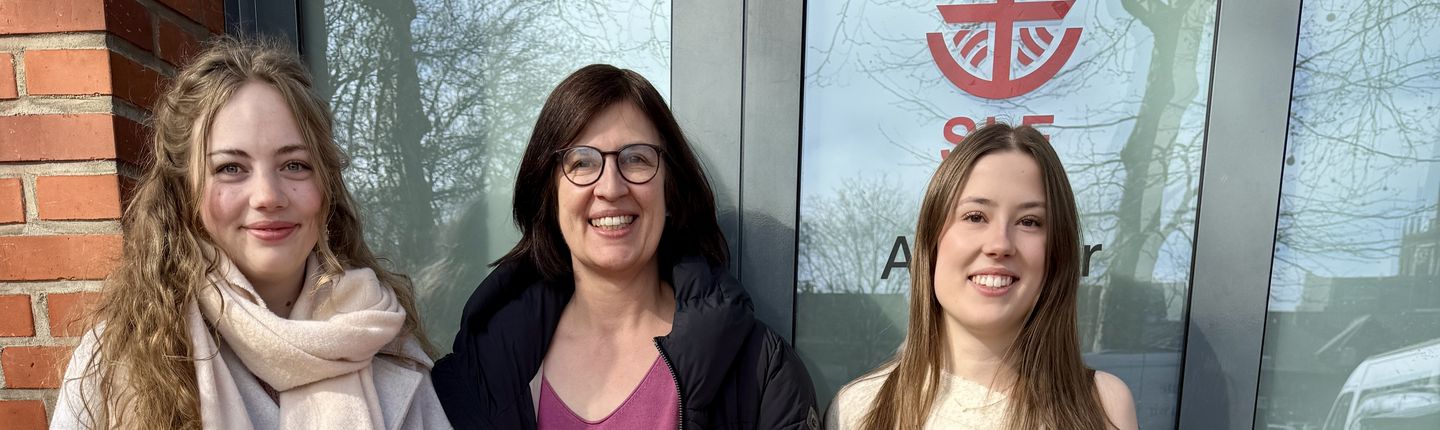 Frau van der Linde und 2 Schülerinnen stehen vor der Tür der Tafel